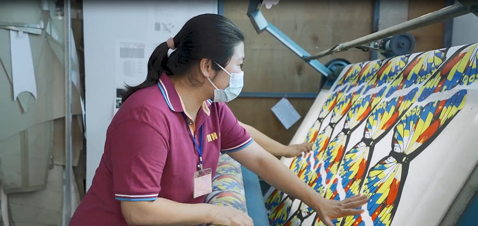 Laboratory technician conducting textile quality tests using specialized equipment with scientific instruments